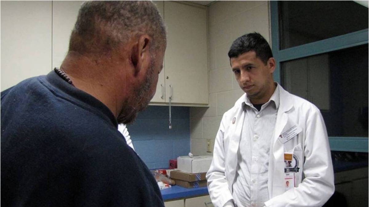 Shows Jaime Carrillo being attentive to a patient.